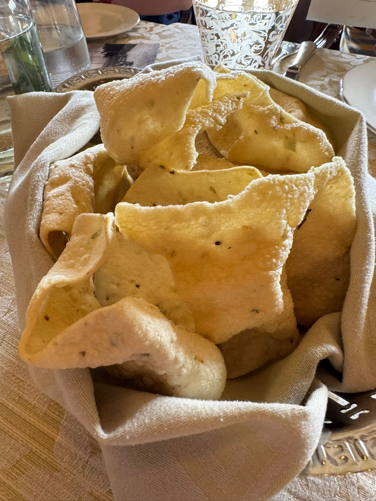 Καλάθι με ύφασμα γεμάτο τραγανά διπλωμένα papad σε ένα τραπέζι εστιατορίου