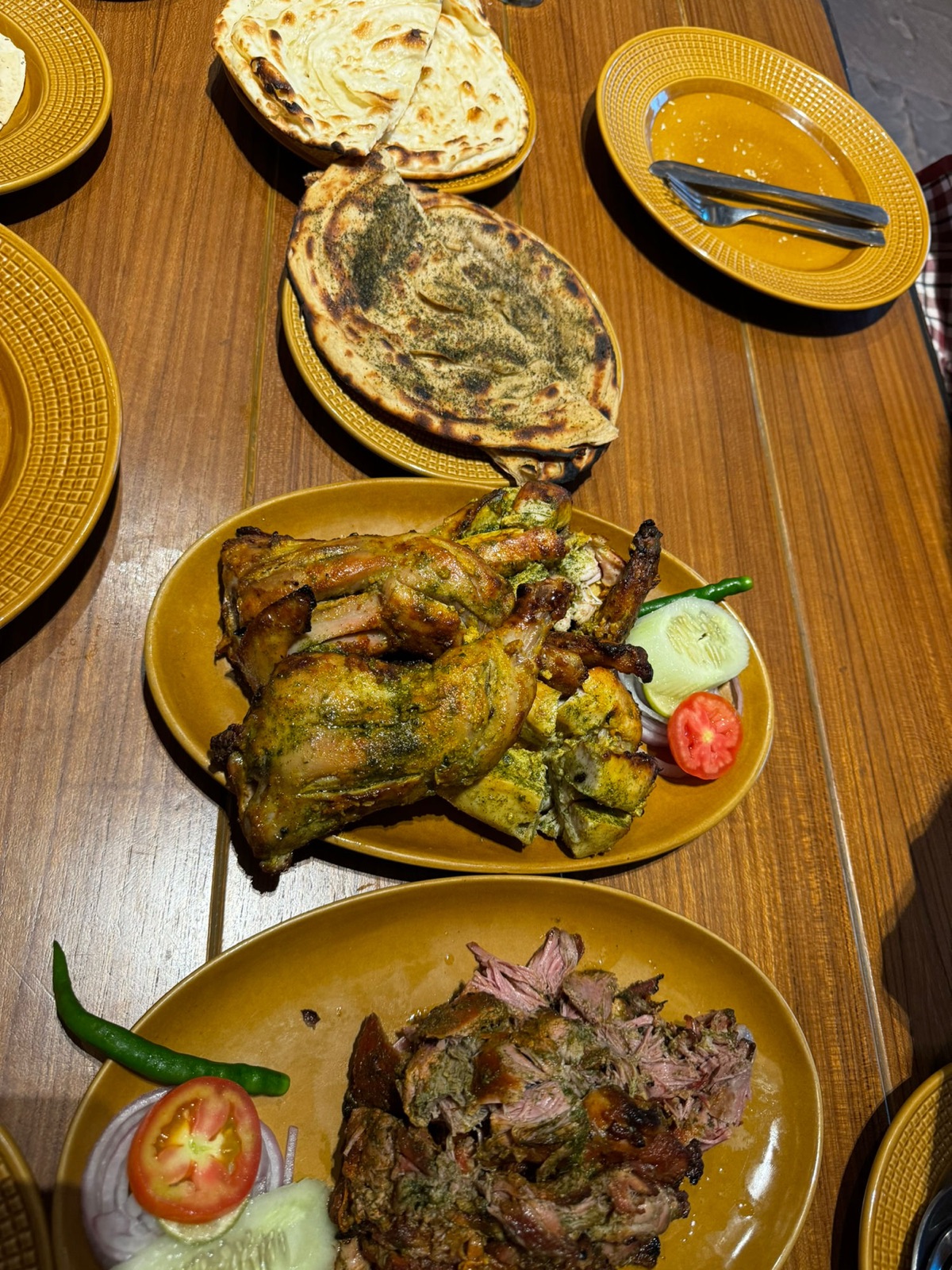 Πιάτα tandoori σε μουσταρδί πιάτα: κοτόπουλο tandoori με πράσινη μαρινάδα, ξεφτισμένο ψητό αρνί και laccha parathas