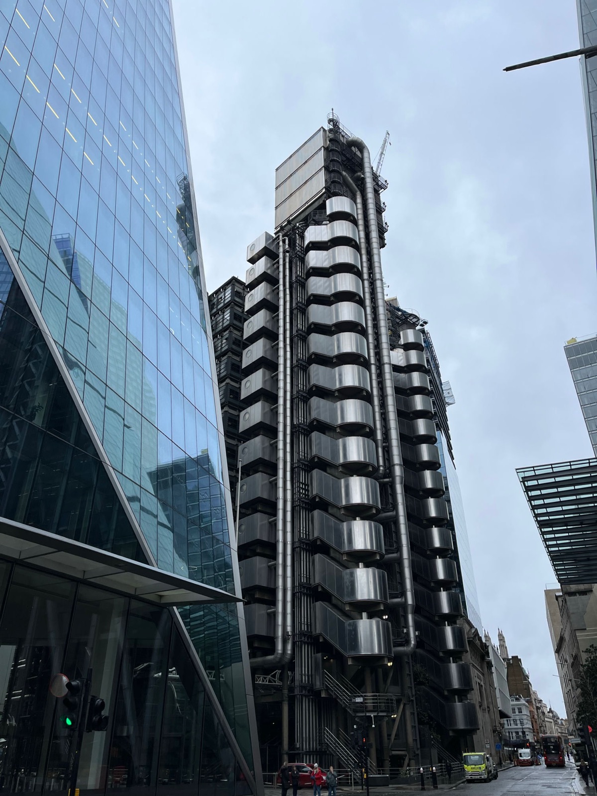 Το κτίριο Lloyd's με τους εξωτερικούς ατσάλινους πύργους υπηρεσιών και τους σωλήνες του, πλαισιωμένο από τον γυάλινο τοίχο του Scalpel μια γκρίζα μέρα
