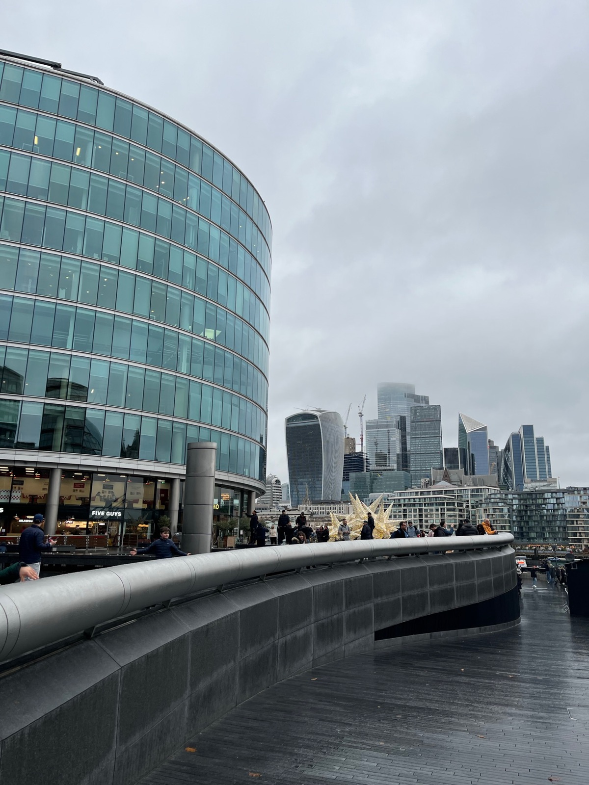 Τα καμπύλα γυάλινα κτίρια του More London με χρυσά χριστουγεννιάτικα αστέρια στην παραποτάμια βόλτα και τους πύργους του City απέναντι στο ποτάμι