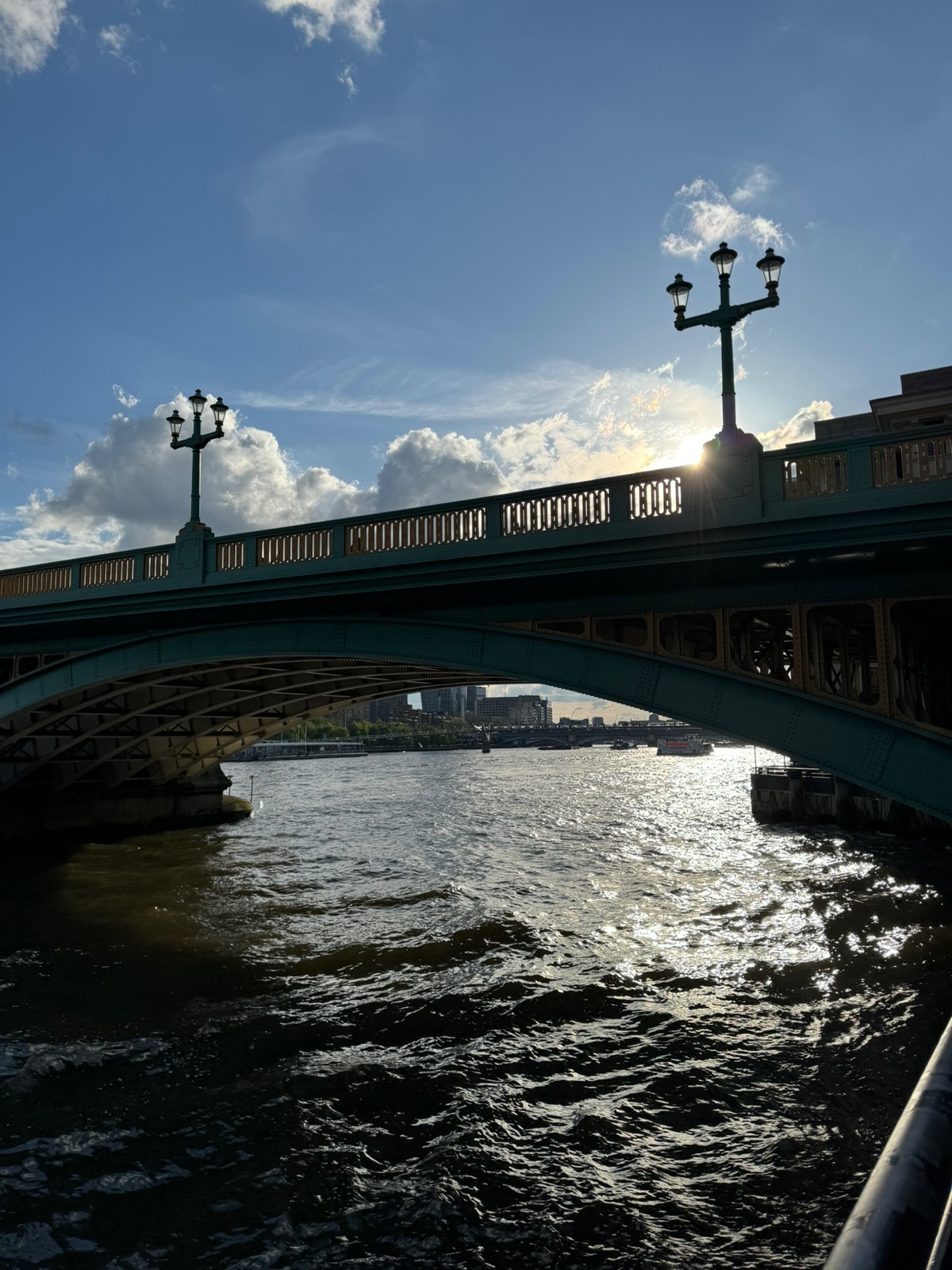 Η Southwark Bridge σε πράσινο και κίτρινο σε σιλουέτα κόντρα στον χαμηλό ήλιο, περίτεχνες λάμπες στο στηθαίο, το ποτάμι να λαμπυρίζει κάτω από την καμάρα