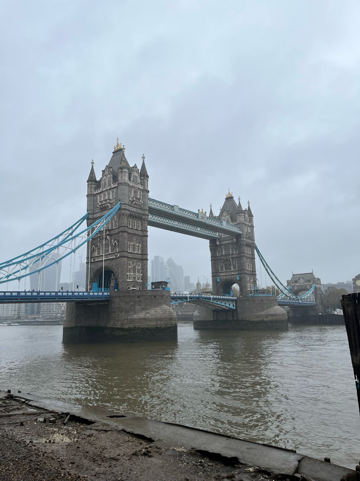 Η Tower Bridge μέσα σε πυκνή ομίχλη, ιδωμένη από τη βόρεια όχθη σε άμπωτη, με τους πύργους του City να διαλύονται στο σύννεφο πίσω της