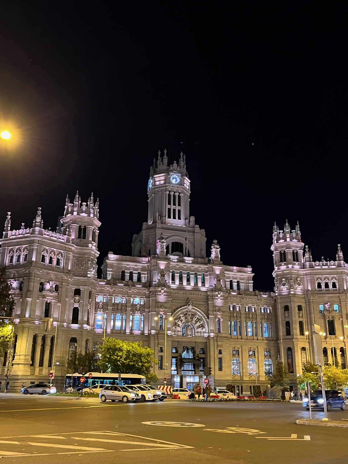 Το λευκό Palacio de Cibeles με τους πυργίσκους του φωτισμένο τη νύχτα με το φεγγάρι ψηλά πάνω από τον πύργο του ρολογιού του