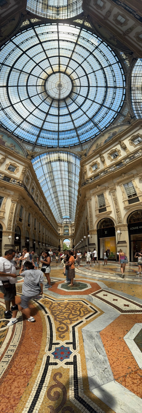 Κατακόρυφο πανόραμα του οκταγώνου της Galleria, από το ψηφιδωτό δάπεδο με τα ελικοειδή σχέδιά του ως πάνω από τις βιτρίνες στον γυάλινο τρούλο