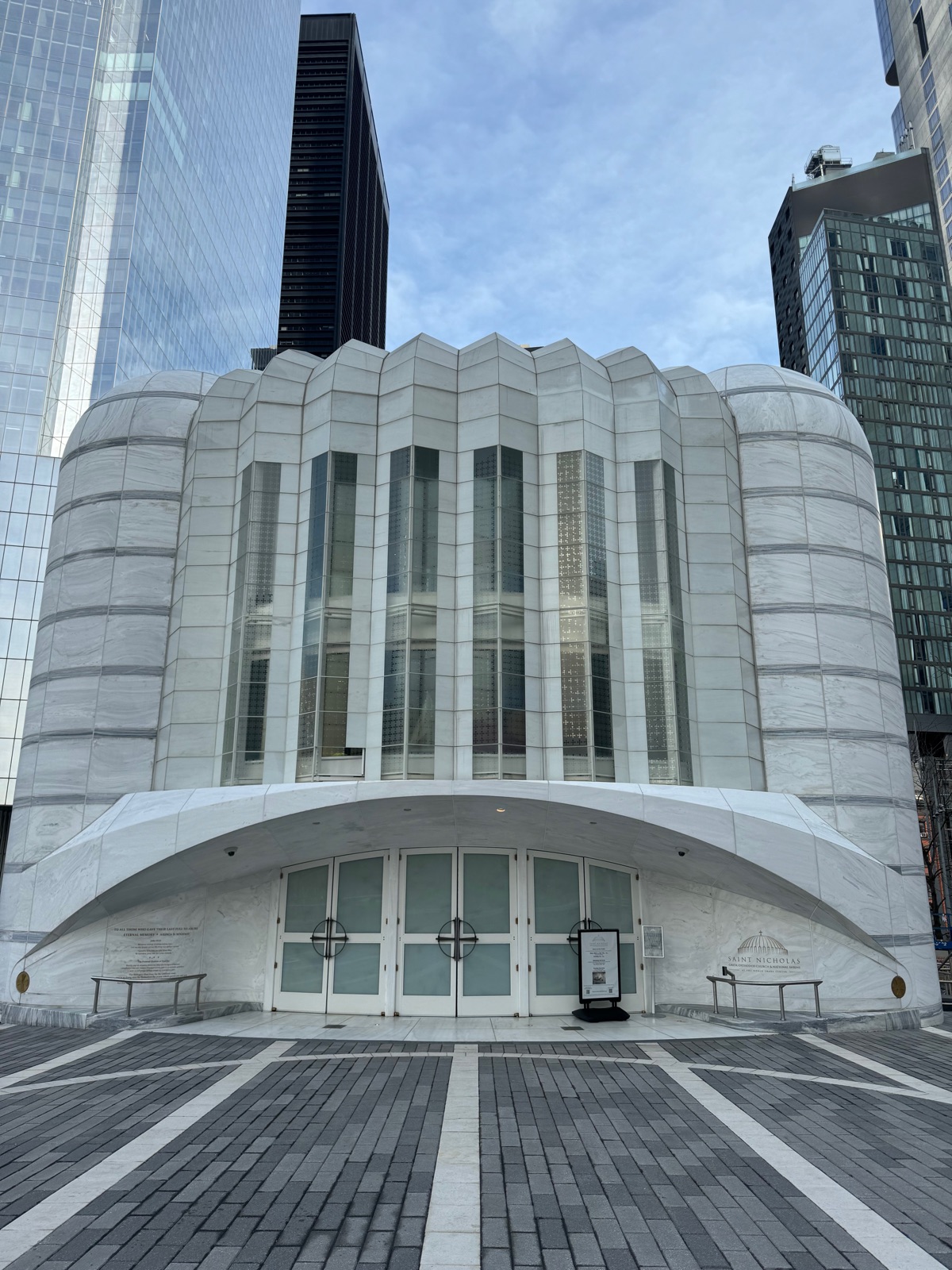 The front of Saint Nicholas Greek Orthodox Church and National Shrine, its fluted white marble facade and long low arch over the glass doors, with the engraved name to the right