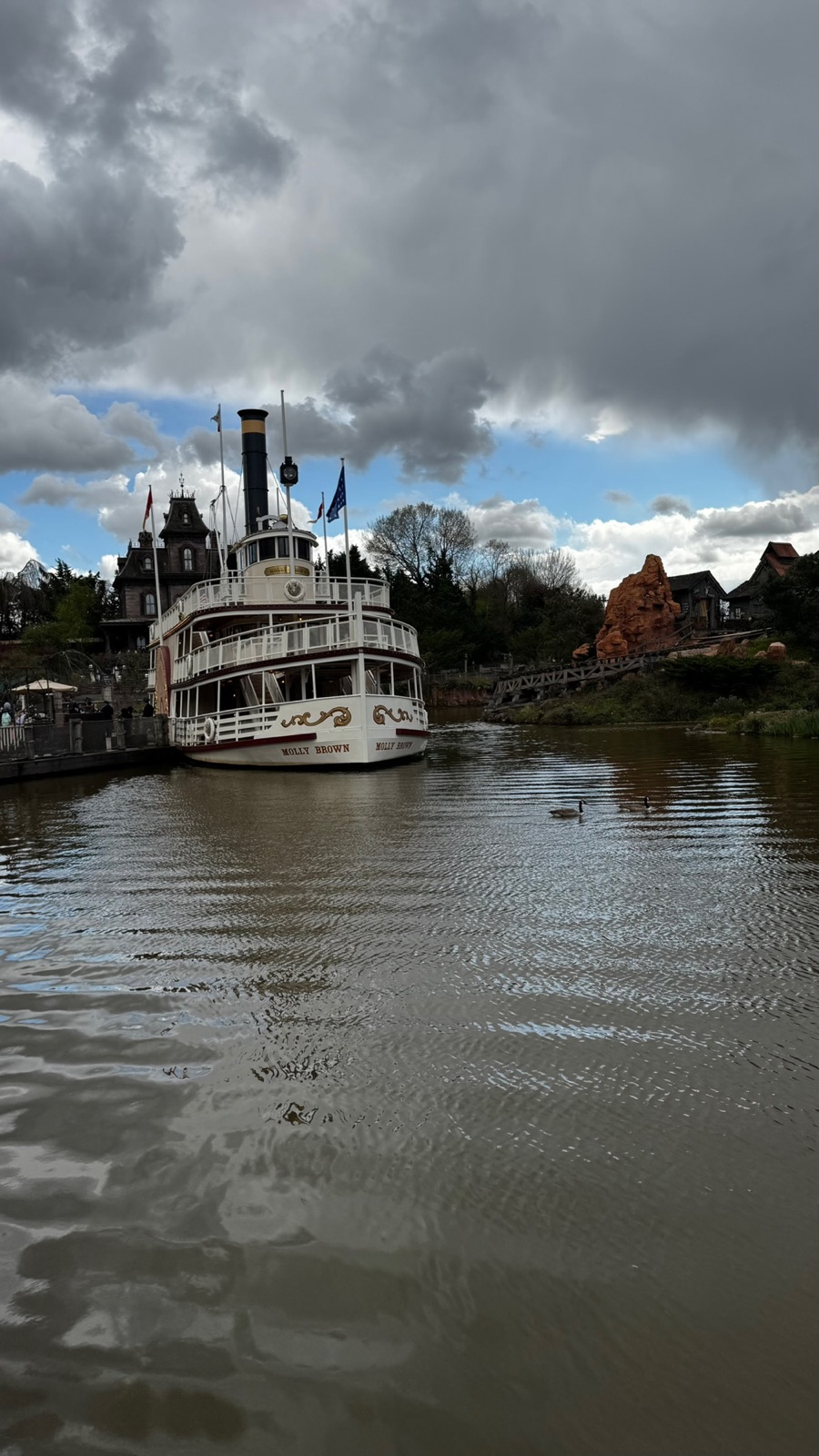 Το λευκό ατμόπλοιο με φτερωτό τροχό Molly Brown δεμένο στα Rivers of the Far West, με το Phantom Manor στον λόφο πίσω και δύο χήνες να κολυμπούν δίπλα