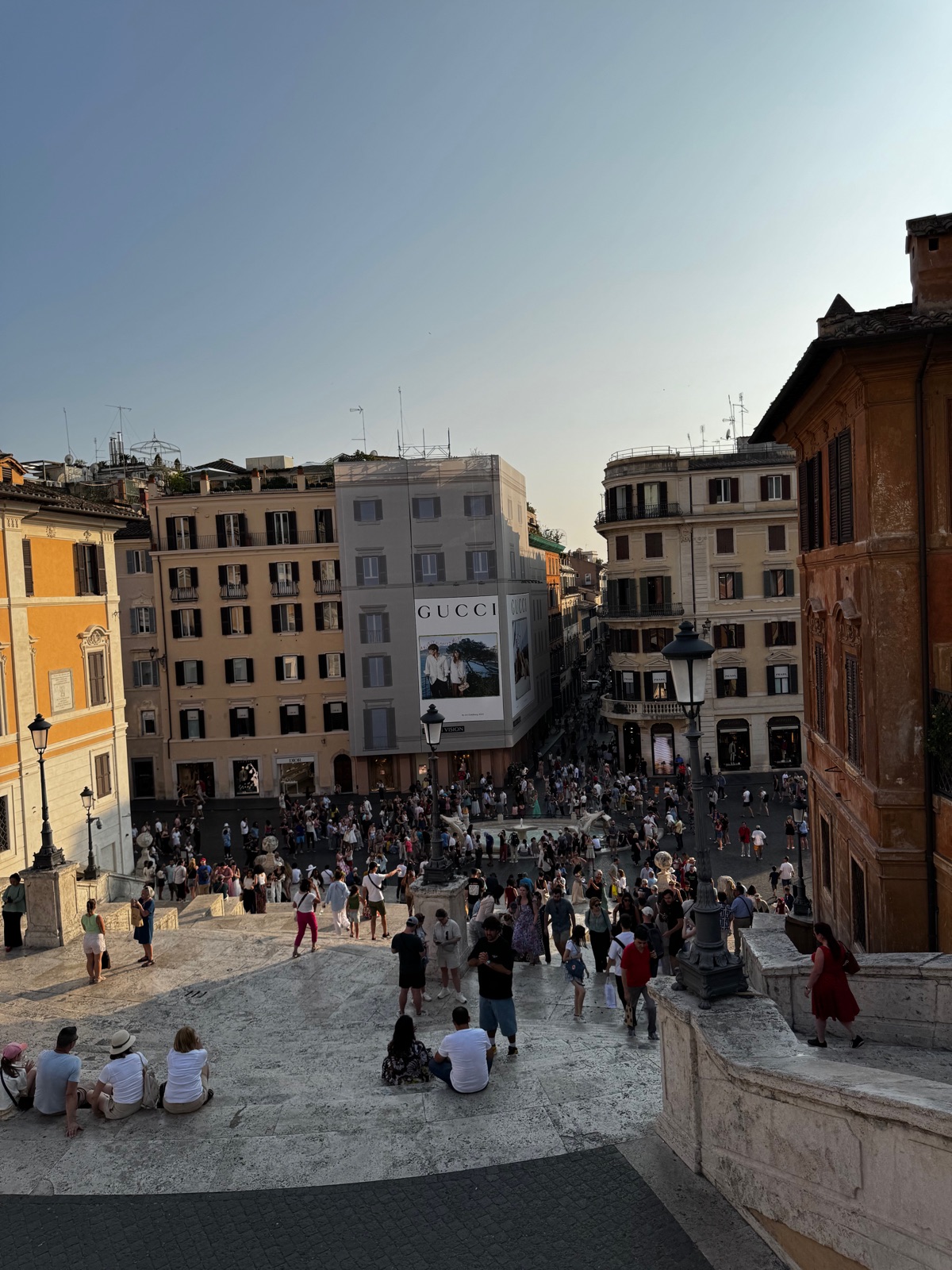 Η Piazza di Spagna από τα μισά της Ισπανικής Σκάλας, ένα μεγάλο πλήθος να γεμίζει την πλατεία κάτω ανάμεσα σε ώχρινα και κρεμ κτίρια